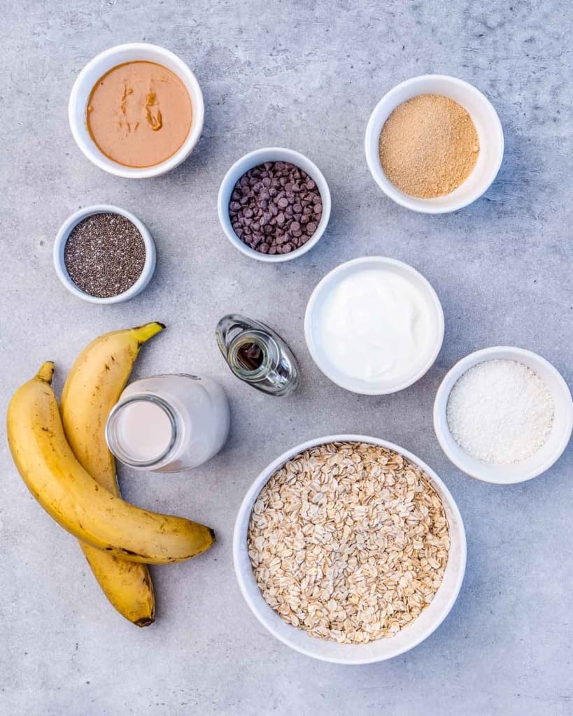 Ingredients for overnight oats divided into small bowls.