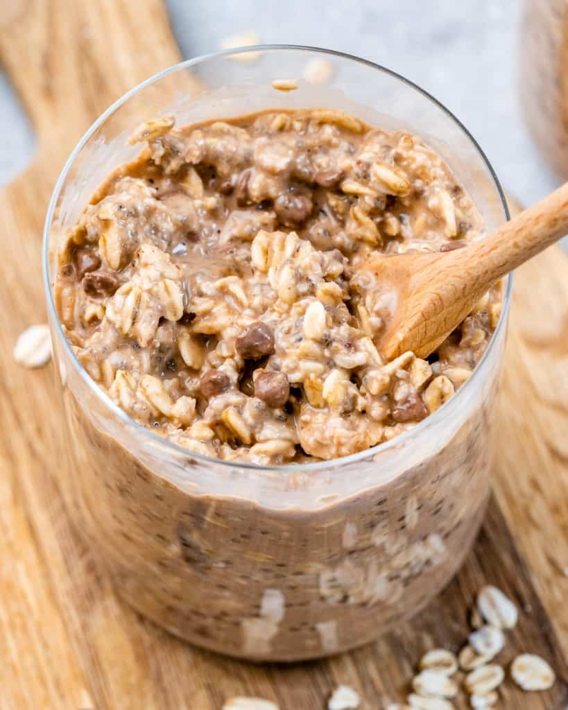 Spoon in a glass jar filled with oatmeal.