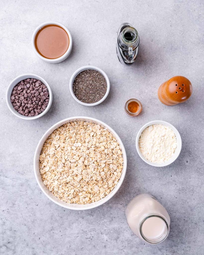 Ingredients for making overnight oats divided into small bowls.