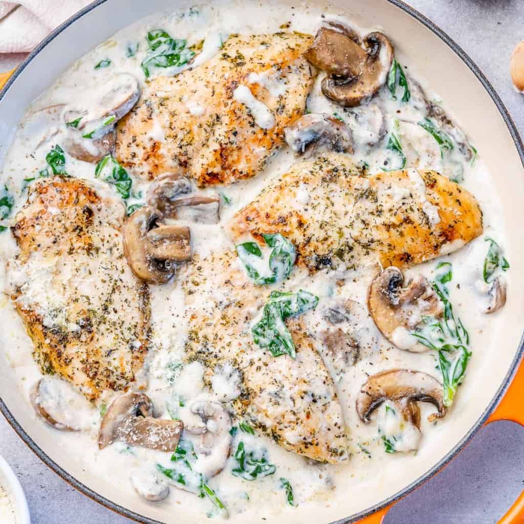 top view creamy chicken skillet with spinach and mushrooms