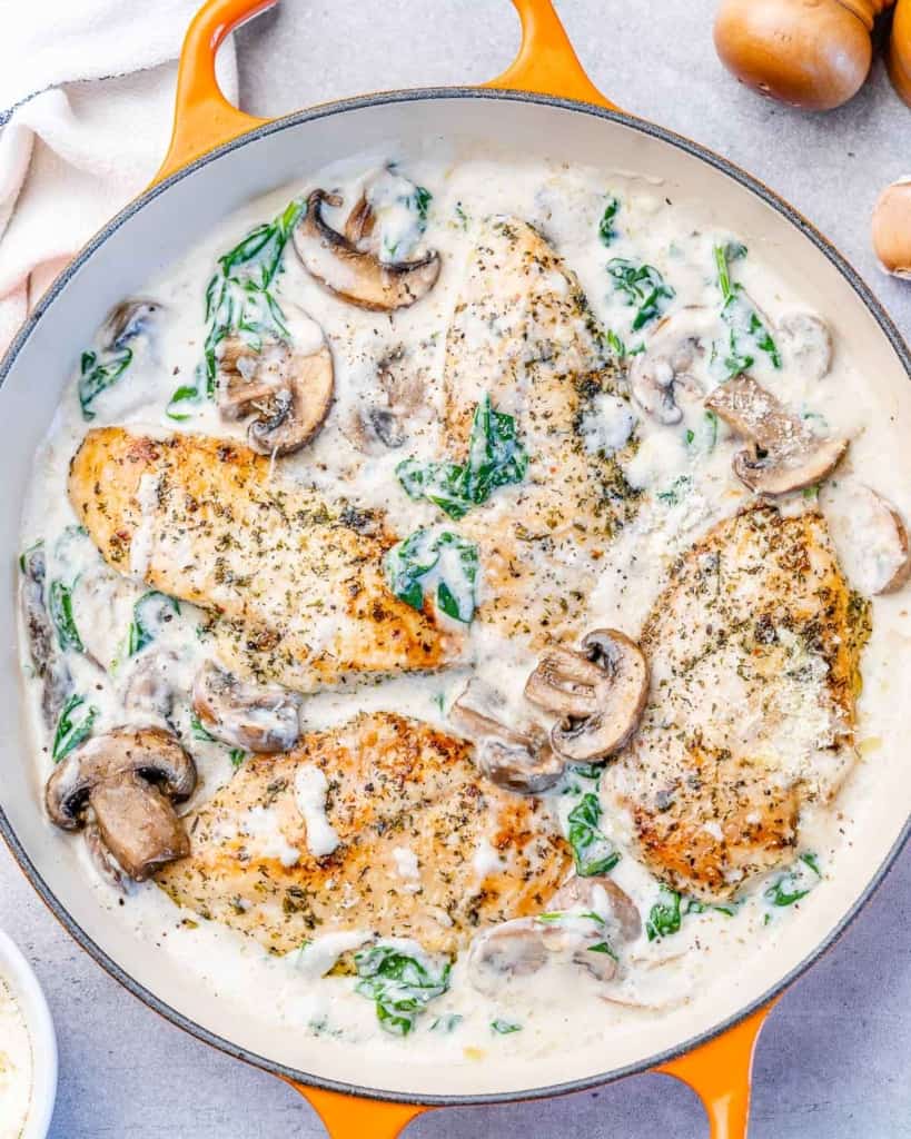 Creamy chicken with parmesan cooking in a skillet.