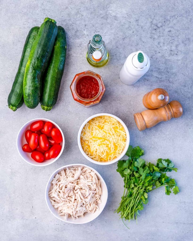 Ingredients needed for zucchini boats divided into portions.