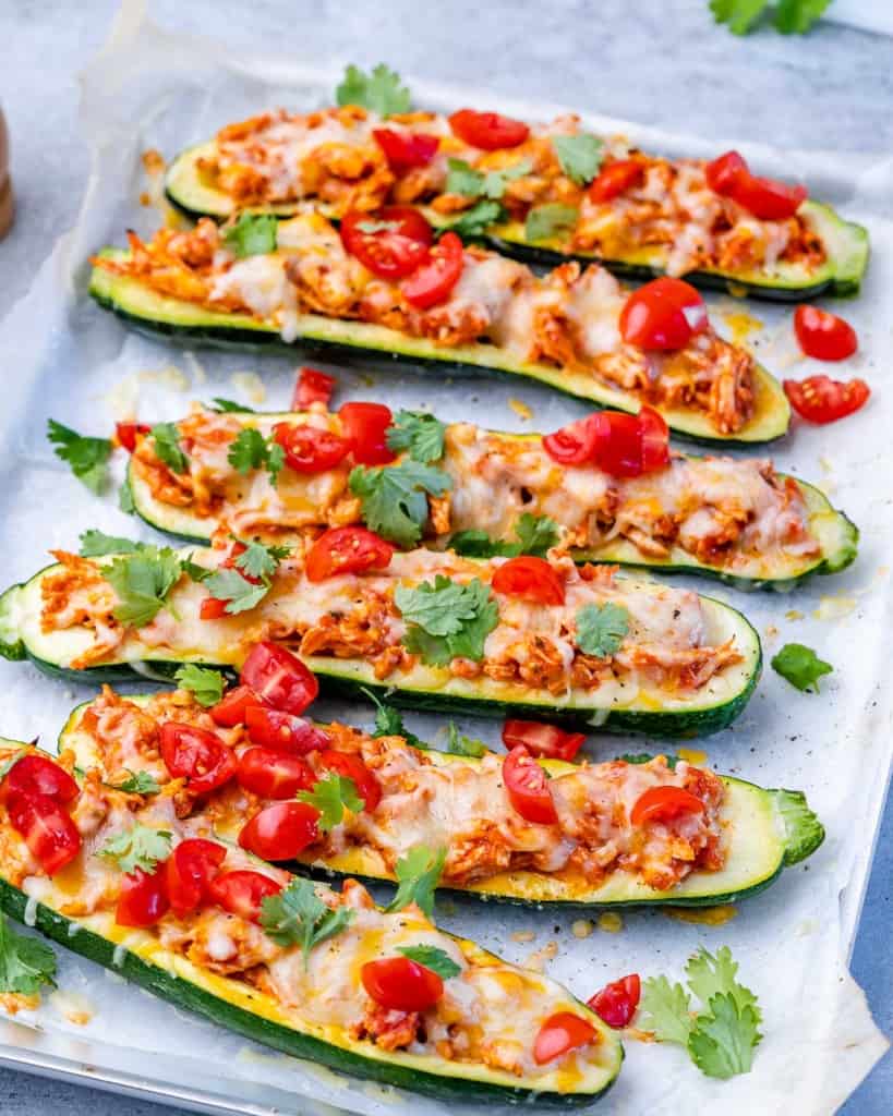 side shot of zucchini boats stuffed with shredded chicken and topped with tomatoes