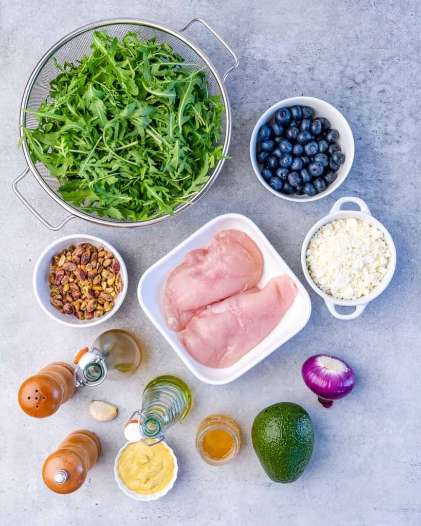 Ingredients divided out to make a chicken arugula salad.
