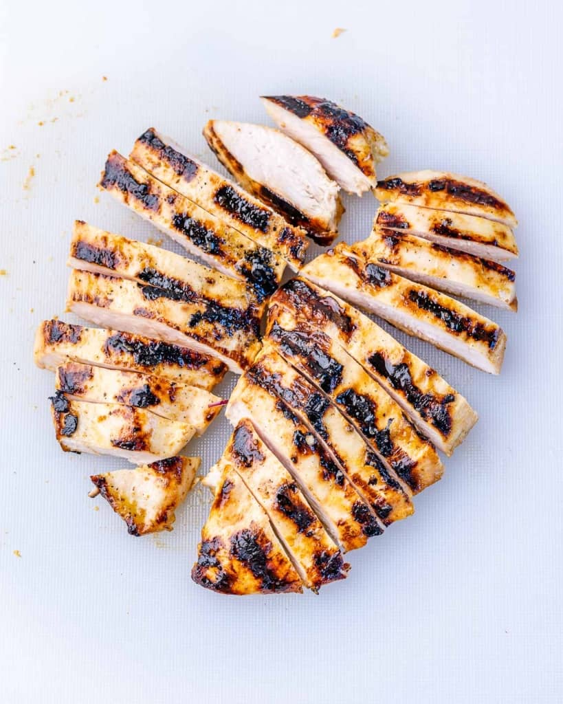 Grilled chicken sliced on a cutting board.