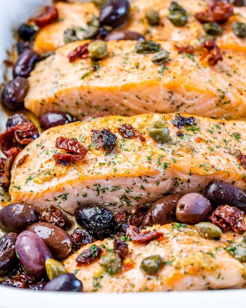close up of baked salmon with kalamata olives and capers