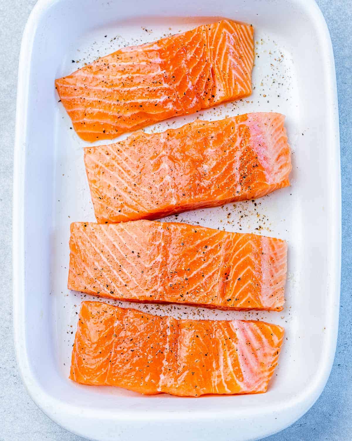 Raw salmon seasoned with salt and pepper.