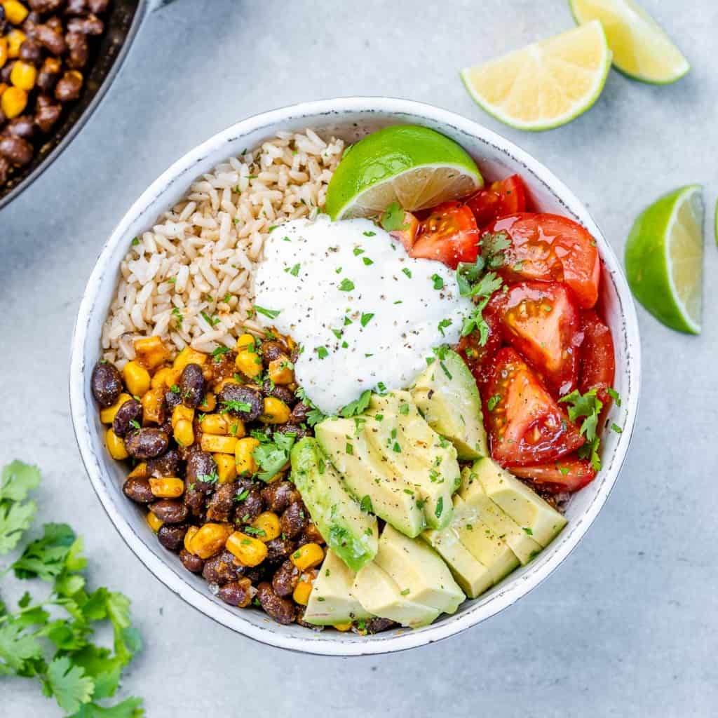 top view bowl of burrito bowl with rice, beans, avocado, tomatoes, and rice