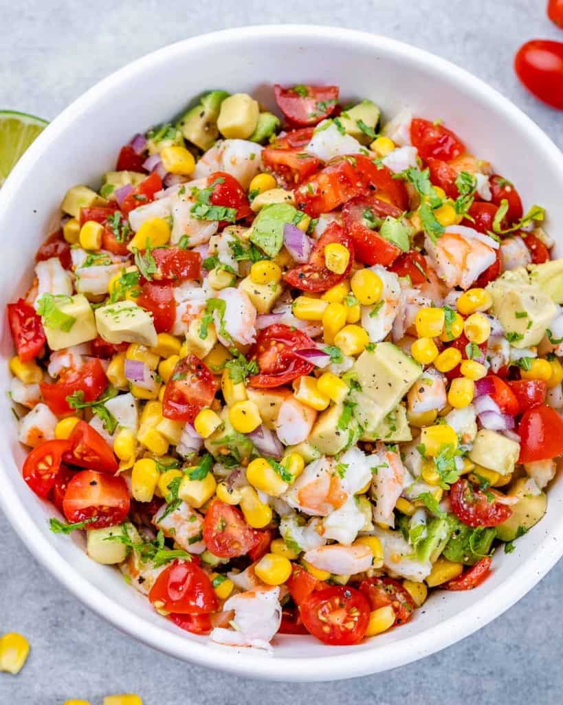 Fresh vegetable salad made with tomatoes, corn, avocado and shrimp.