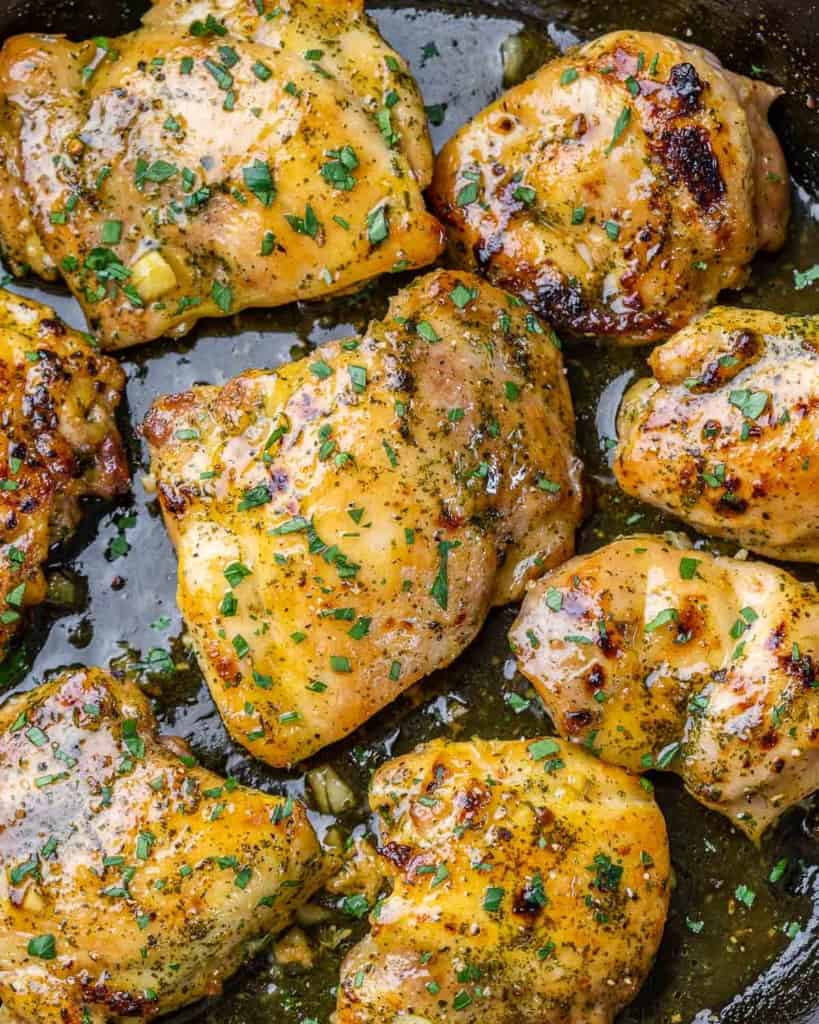close up image of baked chicken thighs in a black skillet