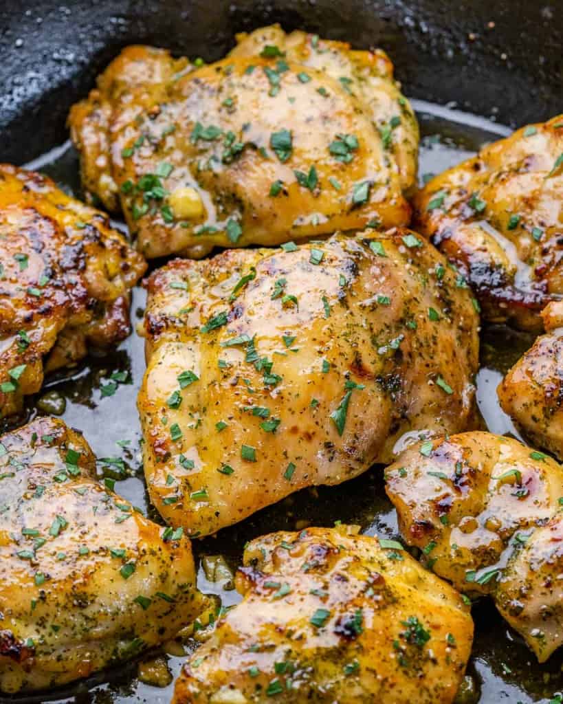 close up chicken thighs in a black skillet