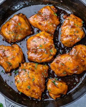 top view of seared adobo chicken thighs in a black skillet