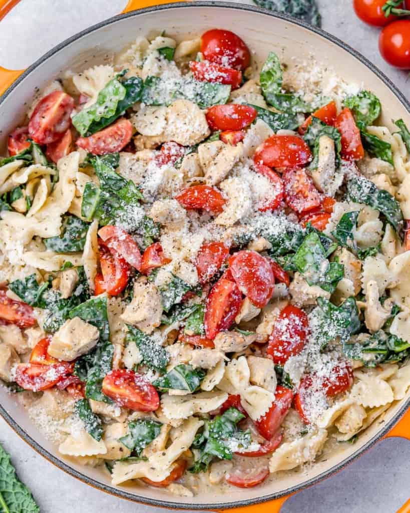 top view of chicken pasta with tomatoes and kale