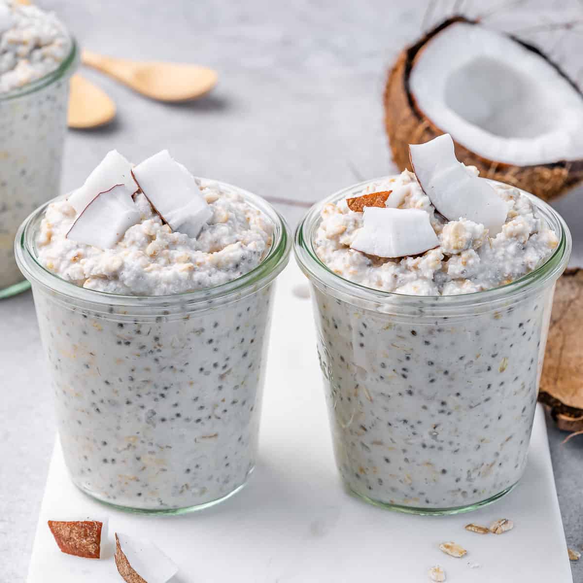 side shot image of 2 jars of overnight oats topped with fresh coconut