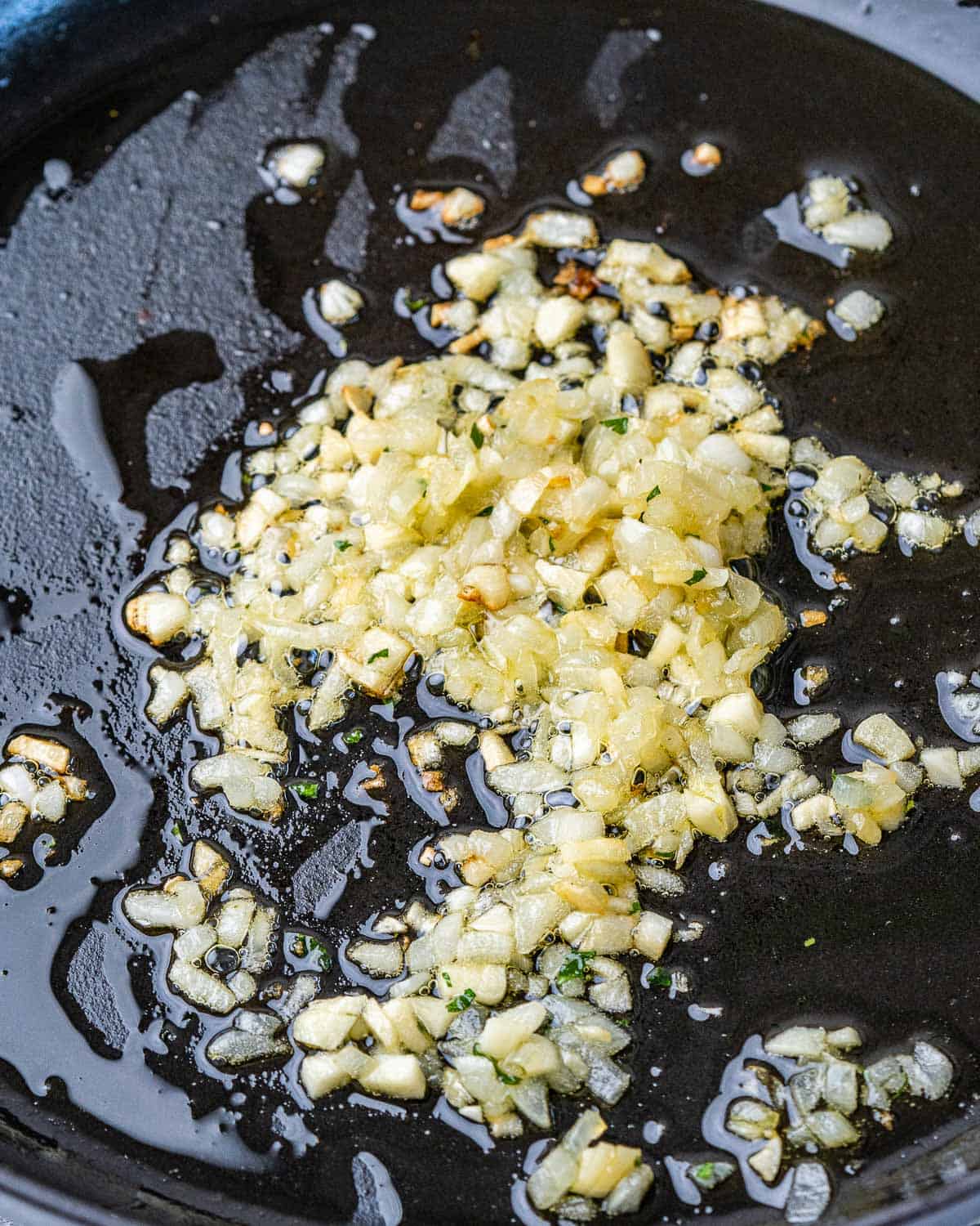 Cooking garlic and onion in a skillet with olive oil.