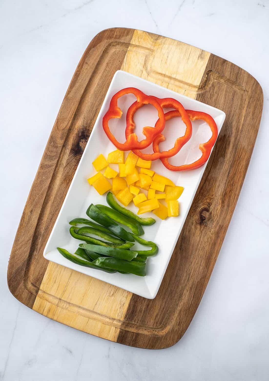 sliced bell peppers on white plate with cutting board