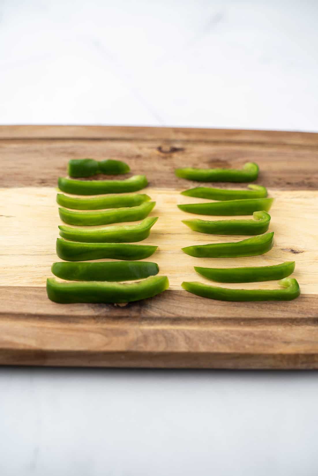 vertical slices of bell pepper on cutting board