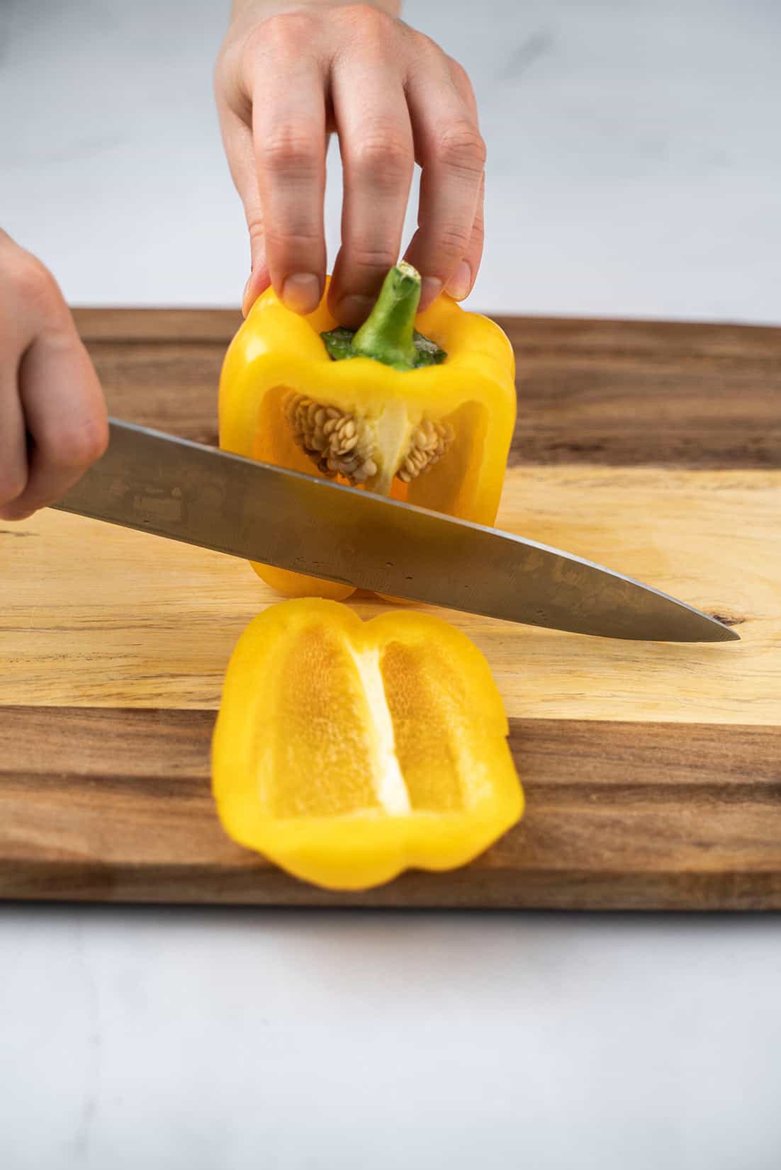 slicing a yellow bell pepper with knife 