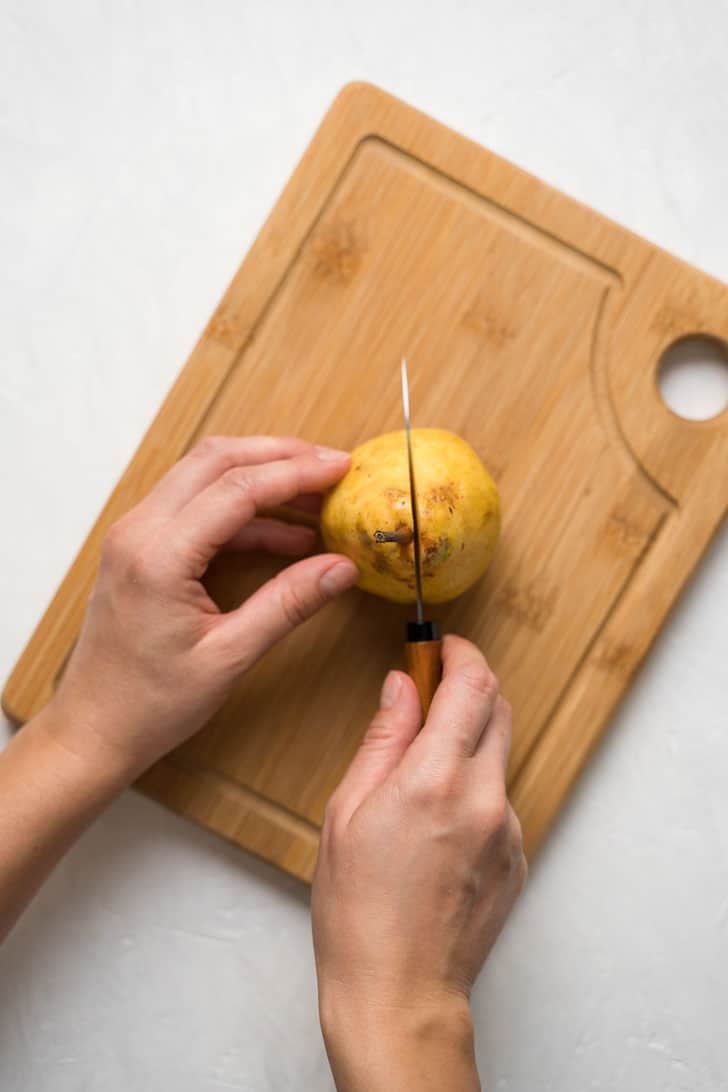 cutting the pear with a knife on board