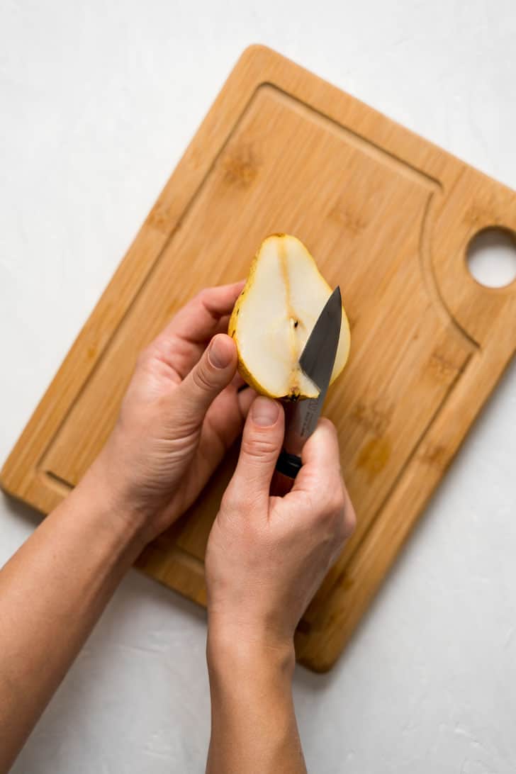 removing the bottom of the pear with a knife 