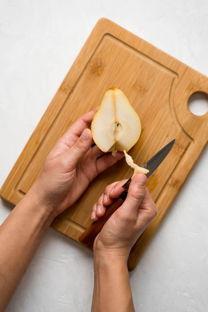 removing bottom of pear with hand 