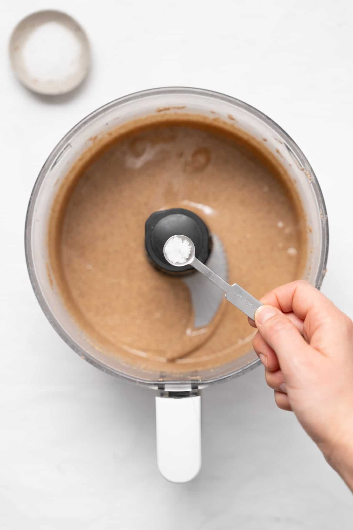 adding salt to almond butter in food processor
