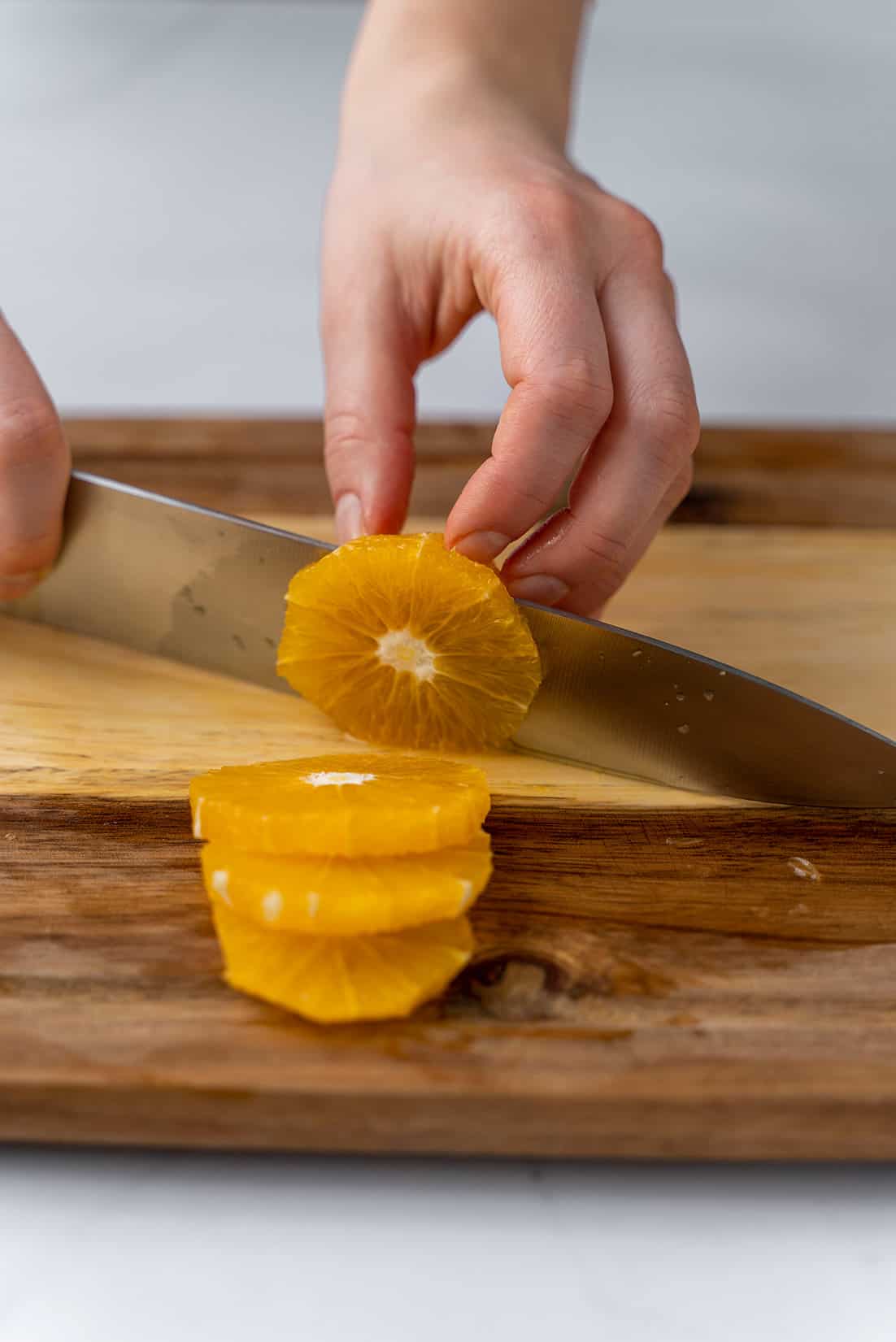 slicing an orange into rings with knife 