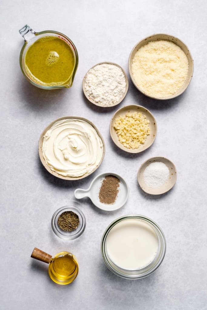 Ingredients for making cream sauce divided into small bowls.