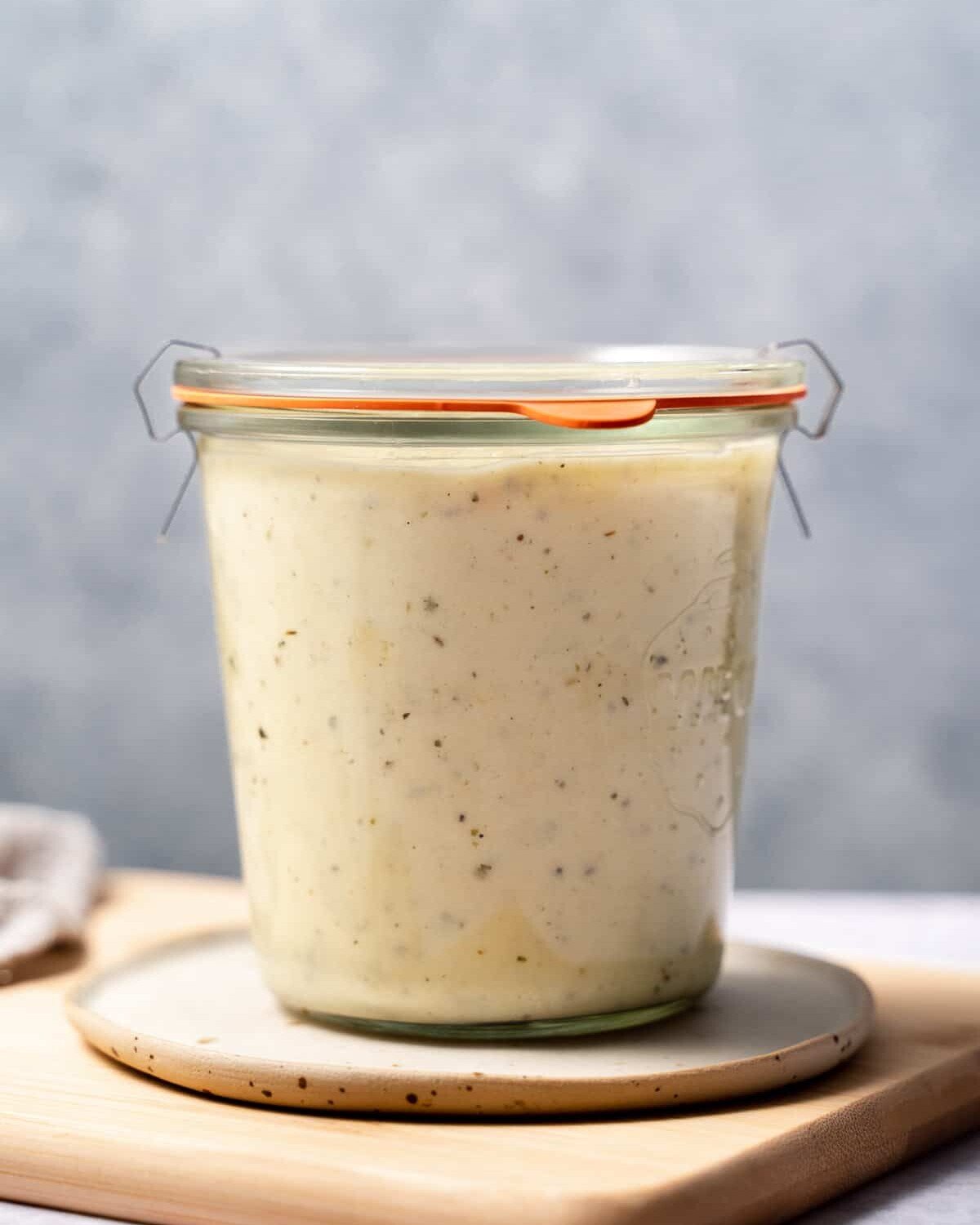 Healthy Alfredo Sauce stored in a glass jar.