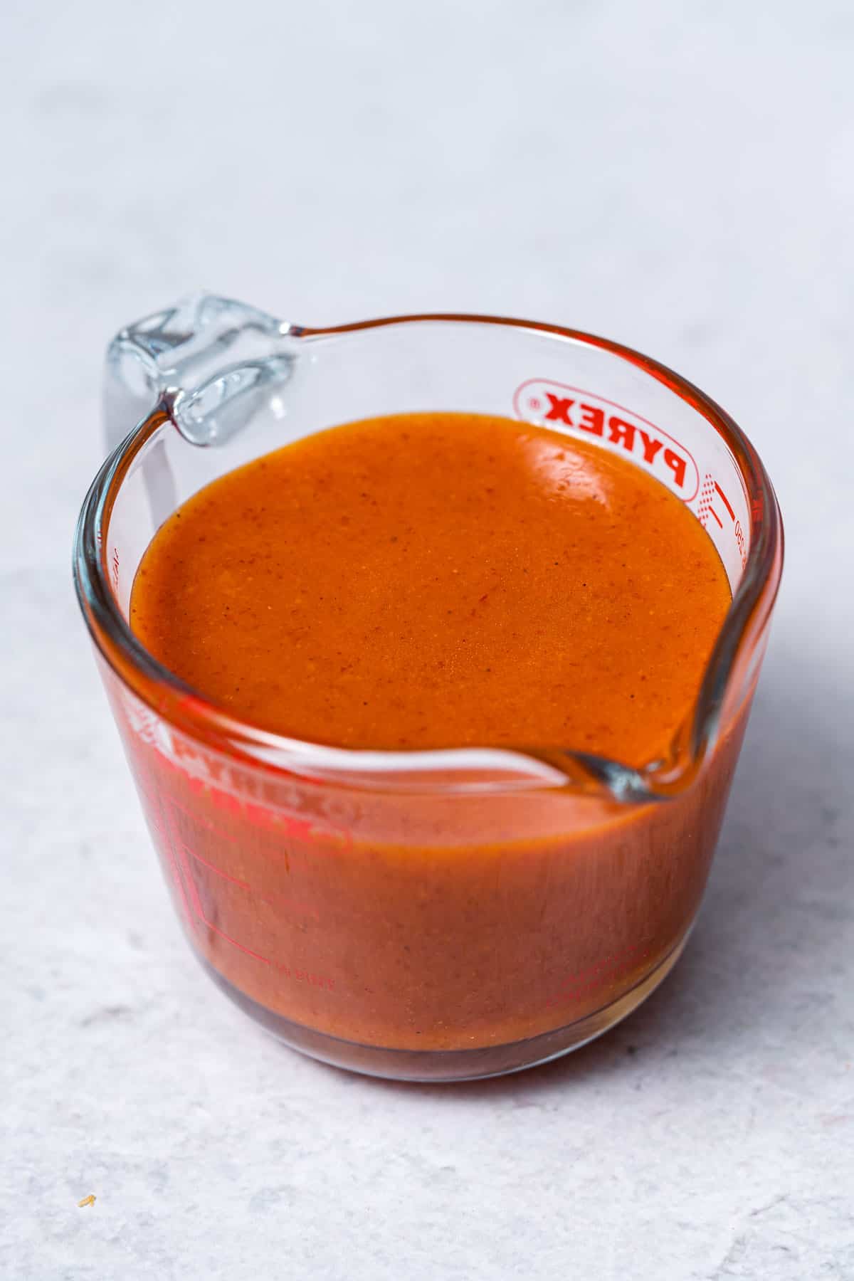 measuring cup filled with buffalo sauce
