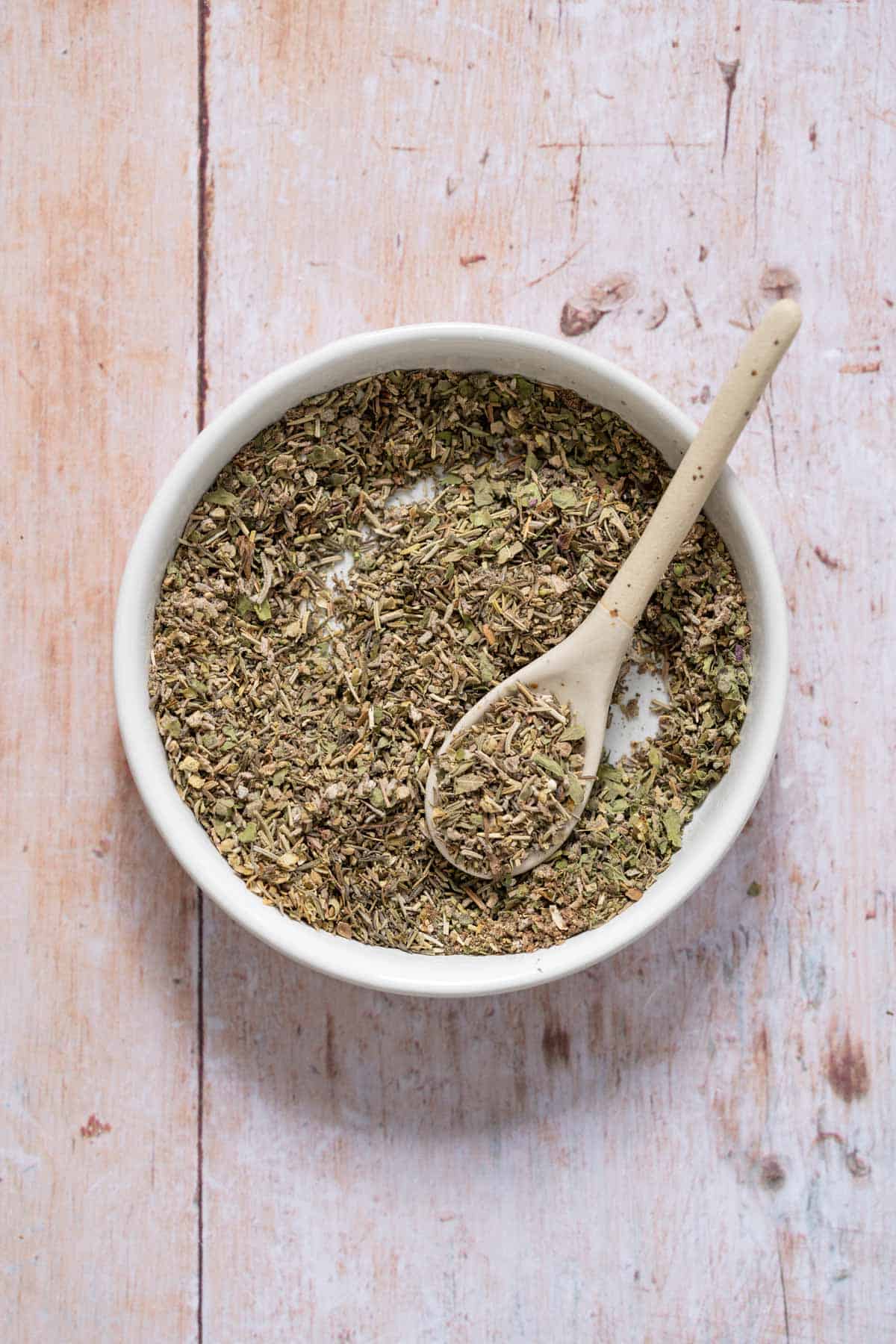 mixed dried herbs with spoon in bowl 