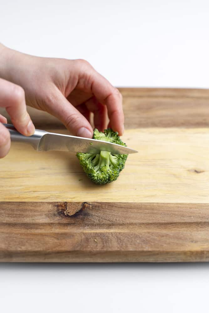 Slicing through a small floret of broccoli.