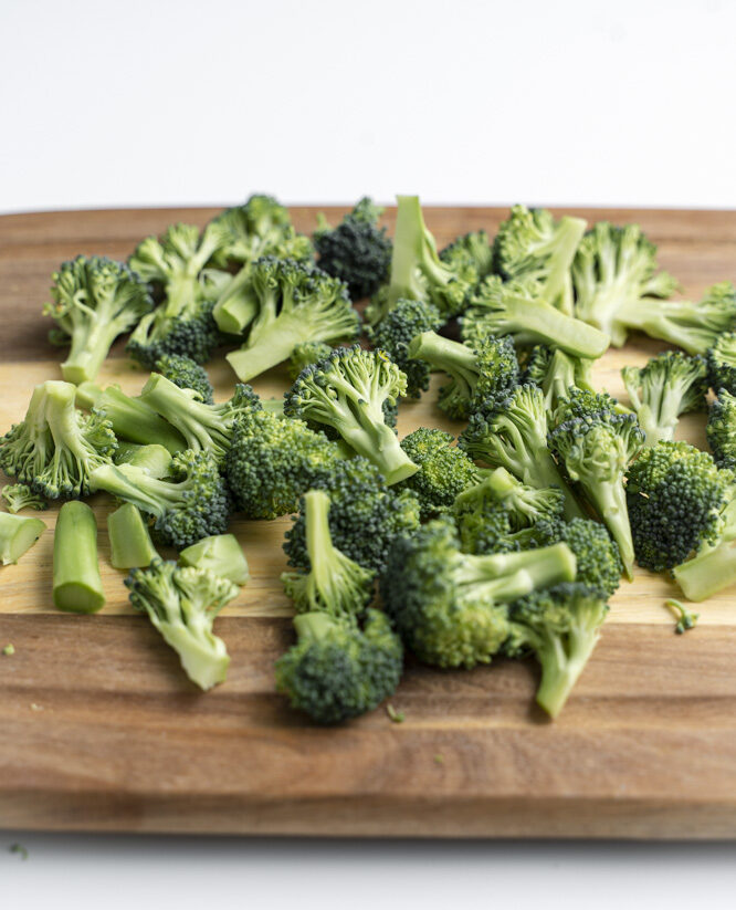 Broccoli florets on a cutting board.