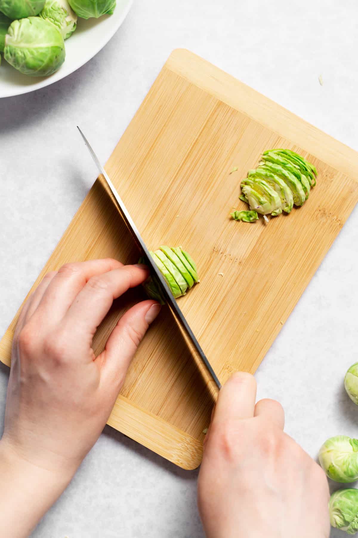 thinly slicing brussels sprouts with knife 