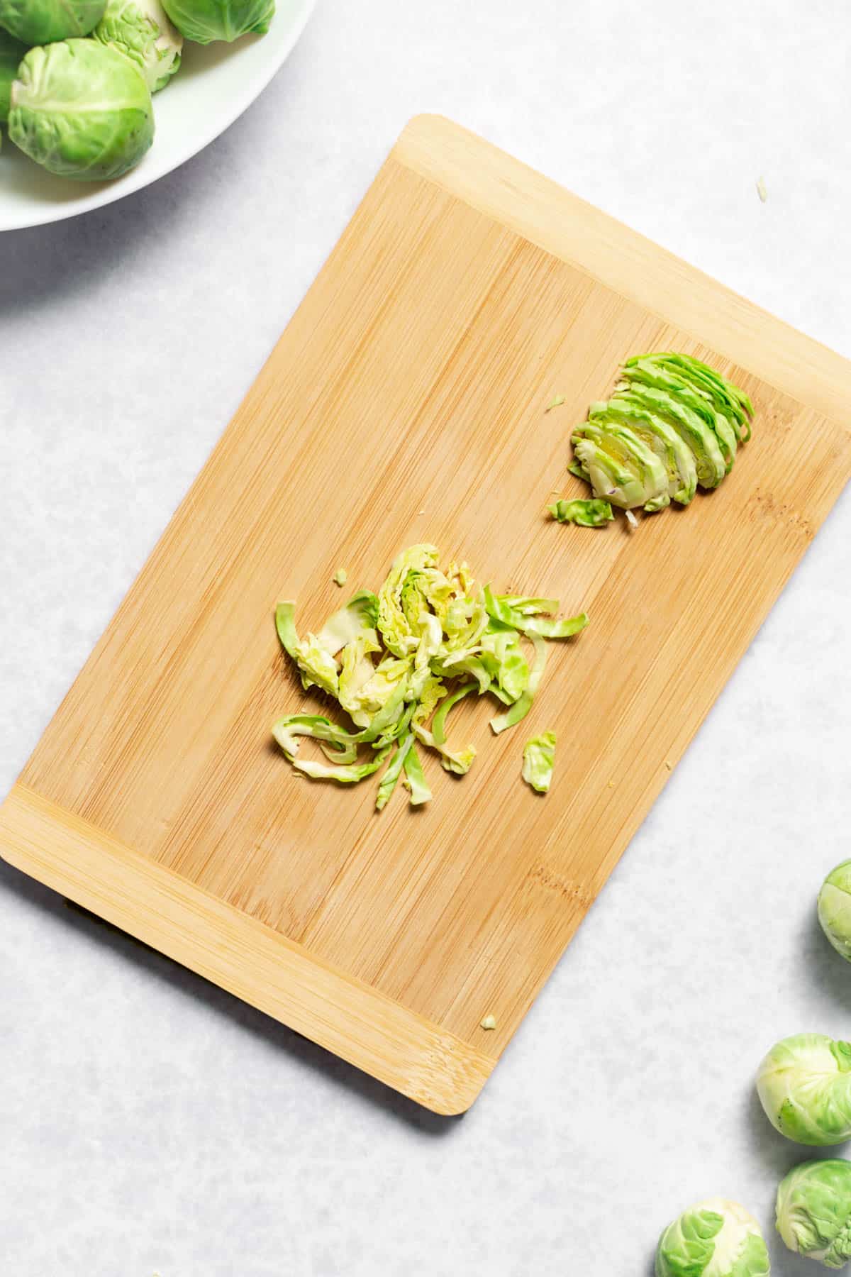 thinly sliced brussels sprouts atop cutting board