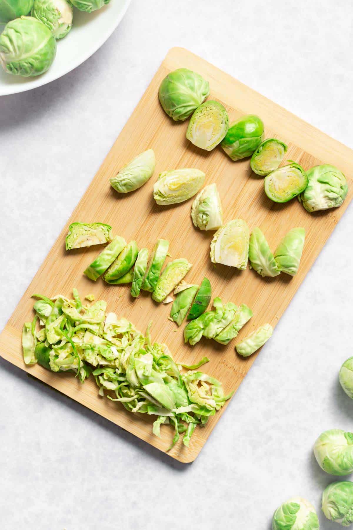 top view of brussel sprouts cut 4 ways on a cutting board