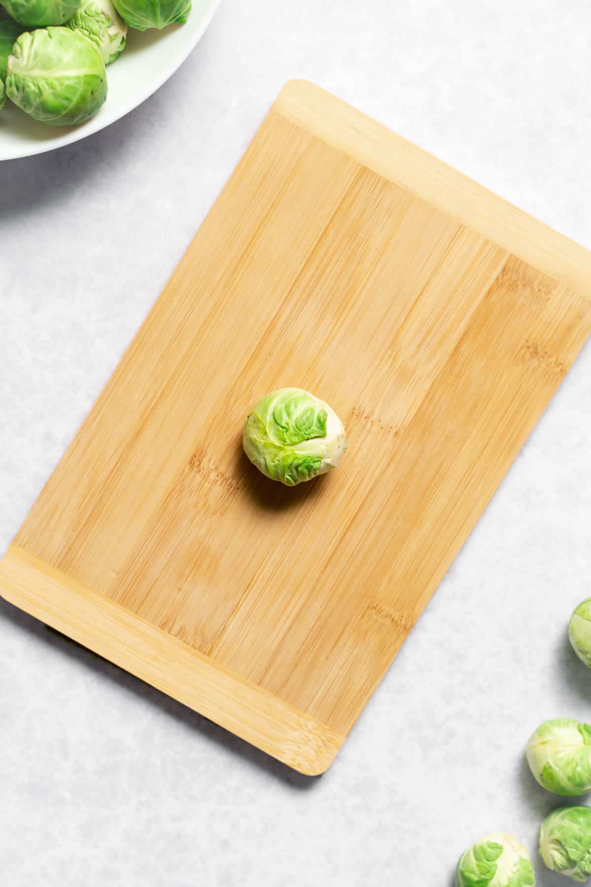 one brussels sprout atop cutting board