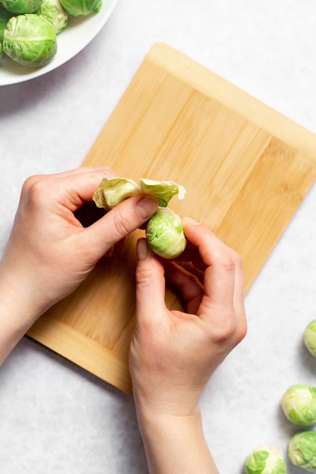 peeling the layers off the brussels sprout with hand 