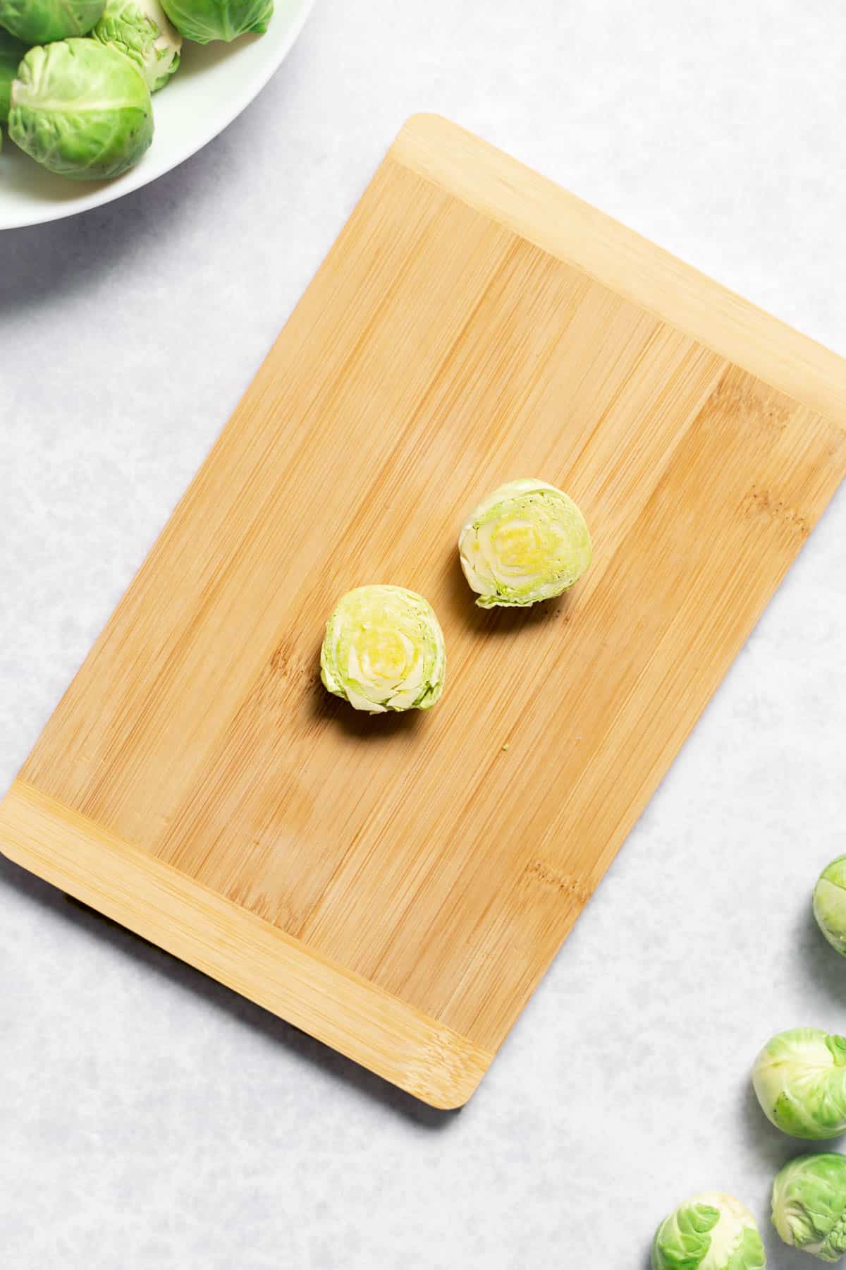 two halves of a brussels sprout on cutting board