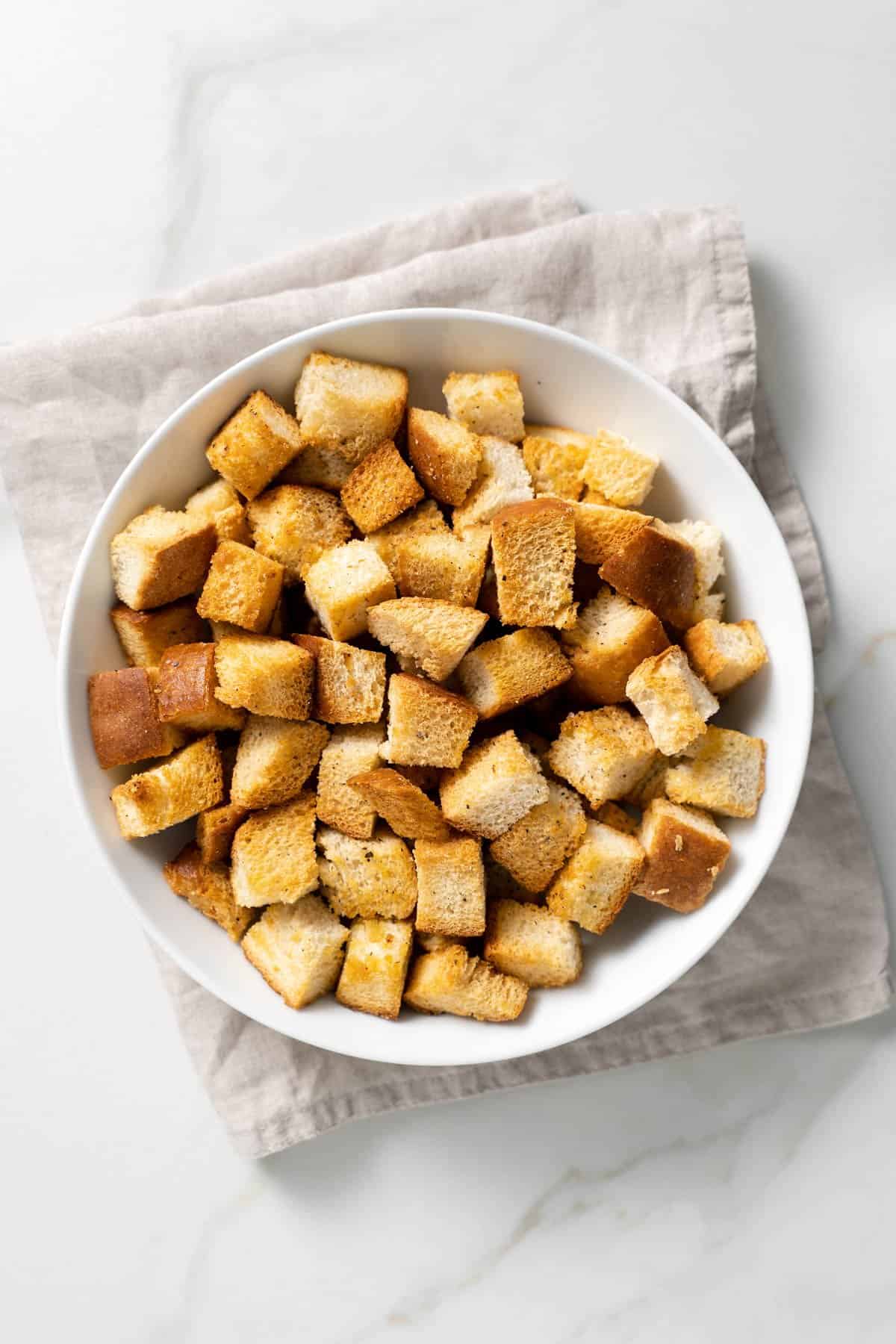 one white bowl filled with baked croutons 