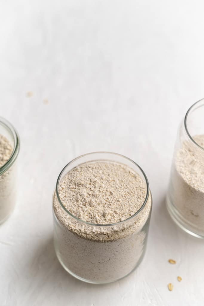 Oat flour in glass jars with the lid off.