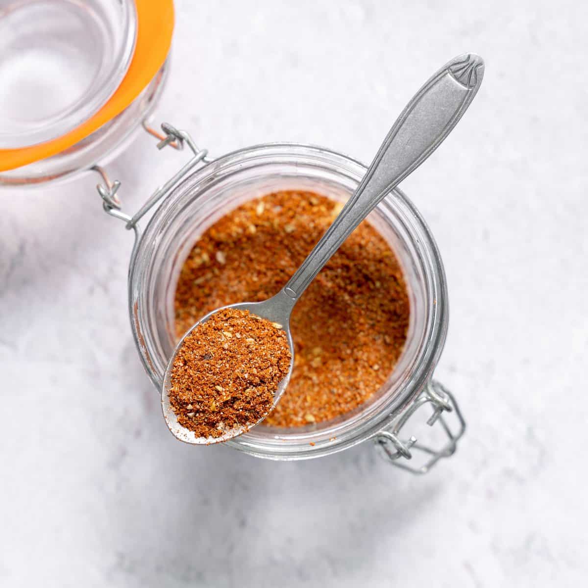 top view taco seasoning in a jar with a spoonful over the jar