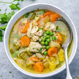 top view turkey soup with veggies in a white bowl