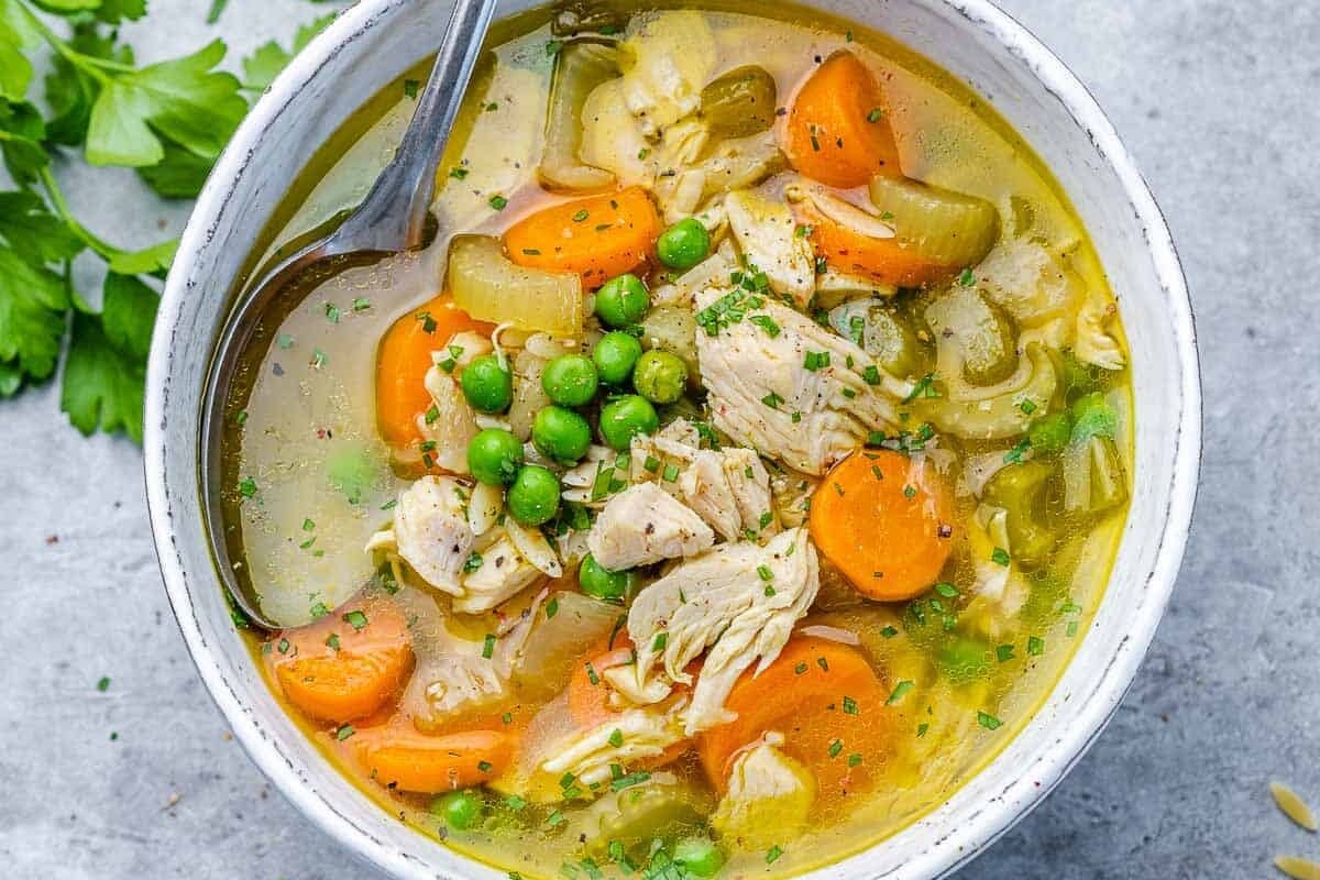 Soup in a white bowl served with a spoon.
