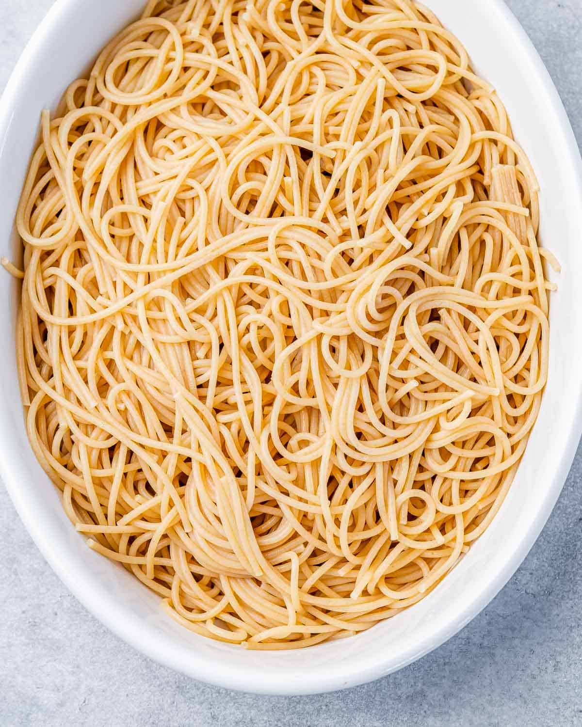 Spaghetti noodles in a white casserole dish.