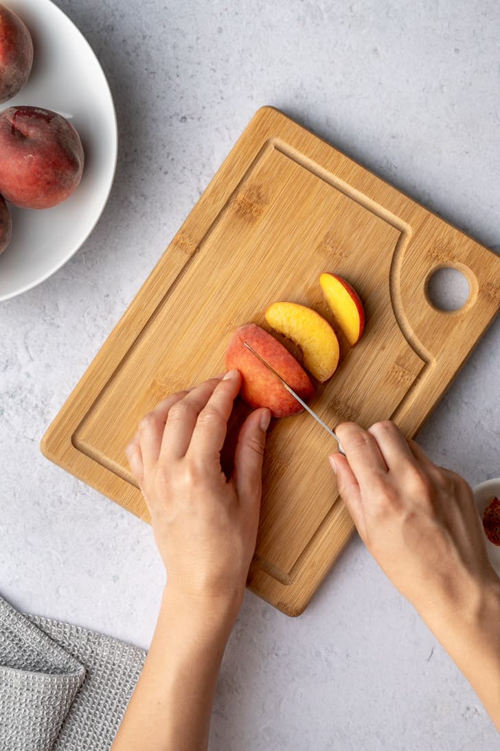 slicing the peach with a knife