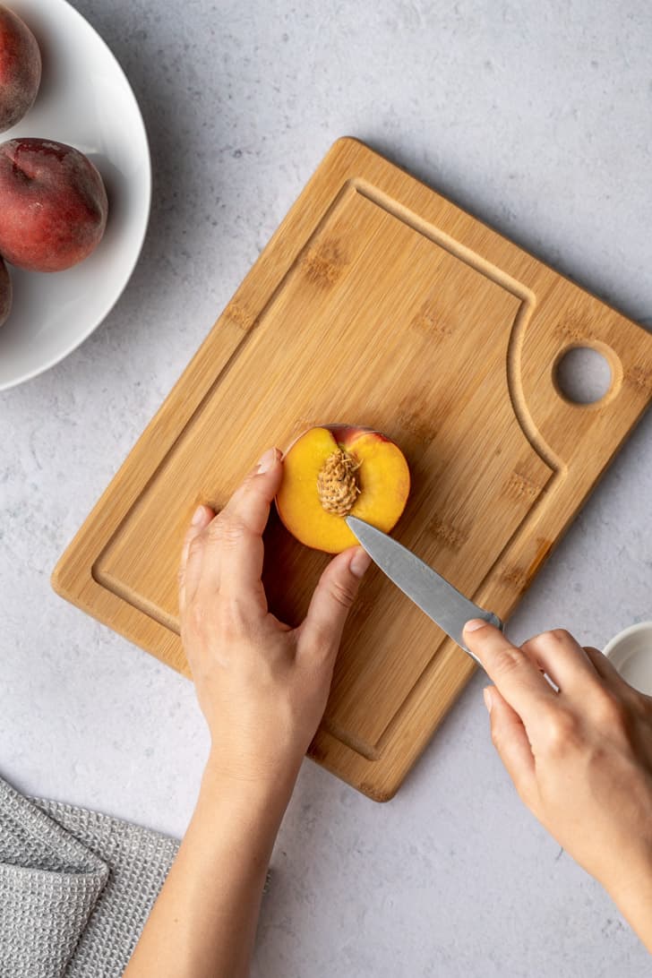 removing the pit of peach with a knife