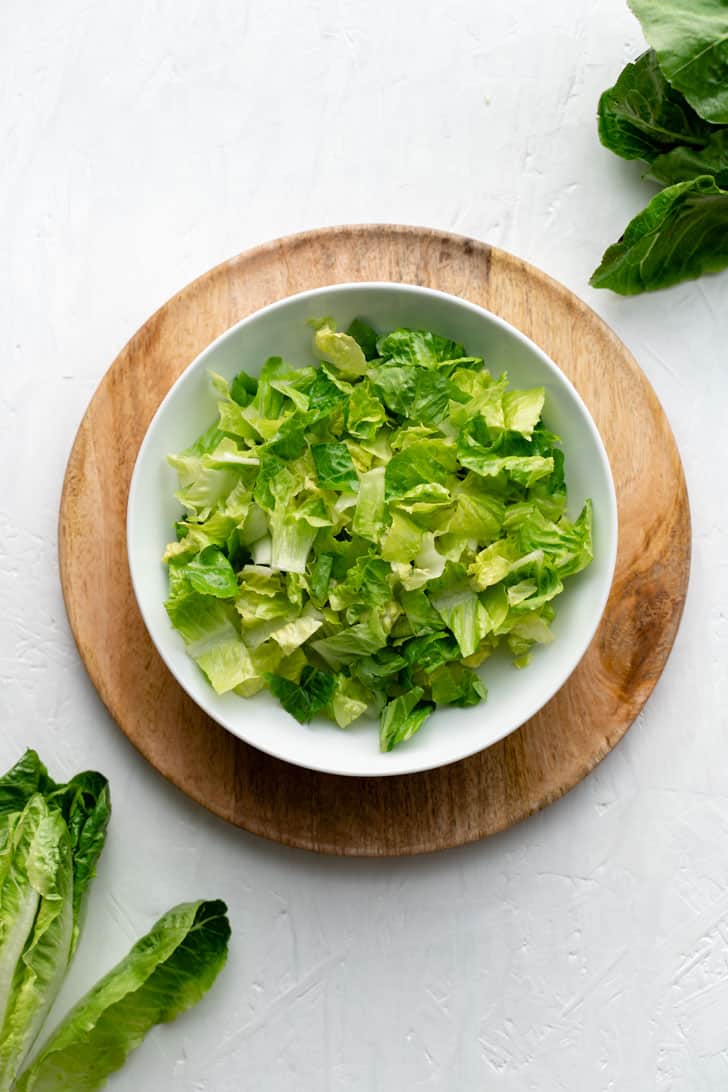 one white bowl filled with chopped romaine lettuce 