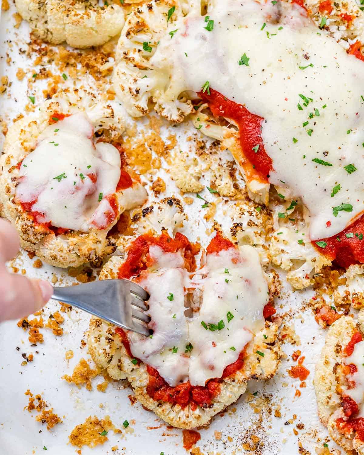 hand holding fork and grabbing a bite of baked cauliflower