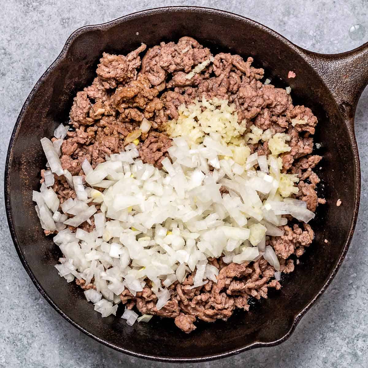 Cooking ground beef and onion in a skillet.